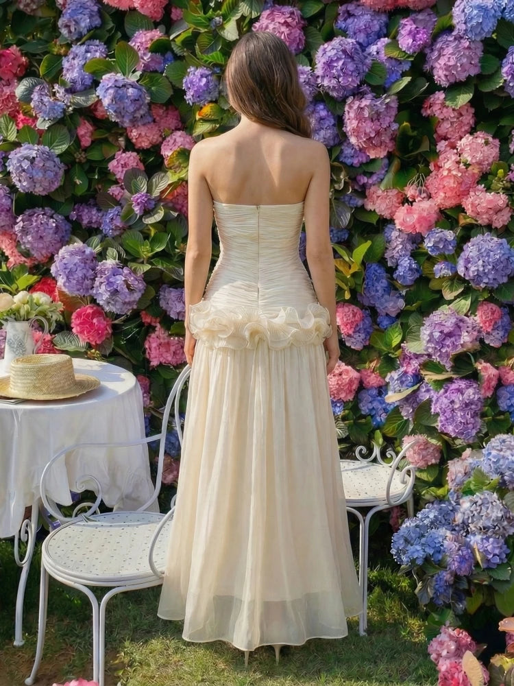 Front pose emphasizing the strapless neckline and gentle ruffle placement, creating a romantic silhouette designed for receptions and celebrations.
