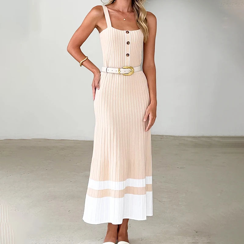 A woman wearing a junior luxury camisole summer gown with a natural waistline and patchwork detailing with a belt against a plain background.