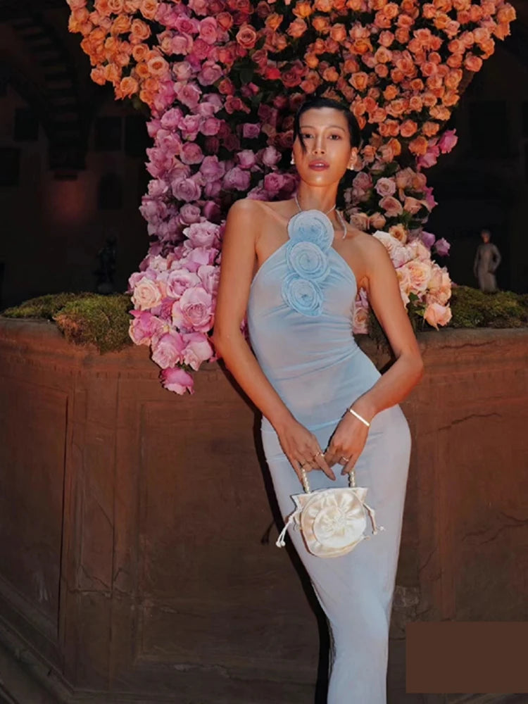 Junior trendy club flower applique dress shown for modern occasions. Woman in a light blue dress standing in front of a floral wall
