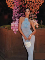 Junior trendy club flower applique dress shown for modern occasions. Woman in a light blue dress standing in front of a floral wall