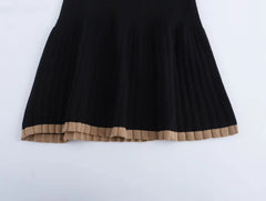 Black dress with a brown hem on a white background