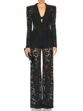 Black sequin outfit with a deep neckline and wide-leg pants on a white background