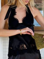 Black lace halter vest top styled for an evening setting with minimal accessories and relaxed posture.