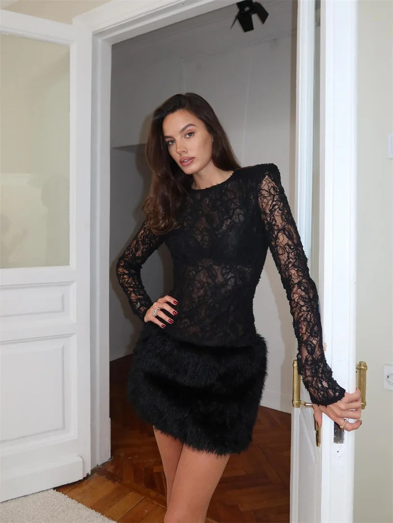 Full view of the lace and fur patchwork dress, highlighting the slim silhouette and soft tactile contrast in a warm indoor setting.