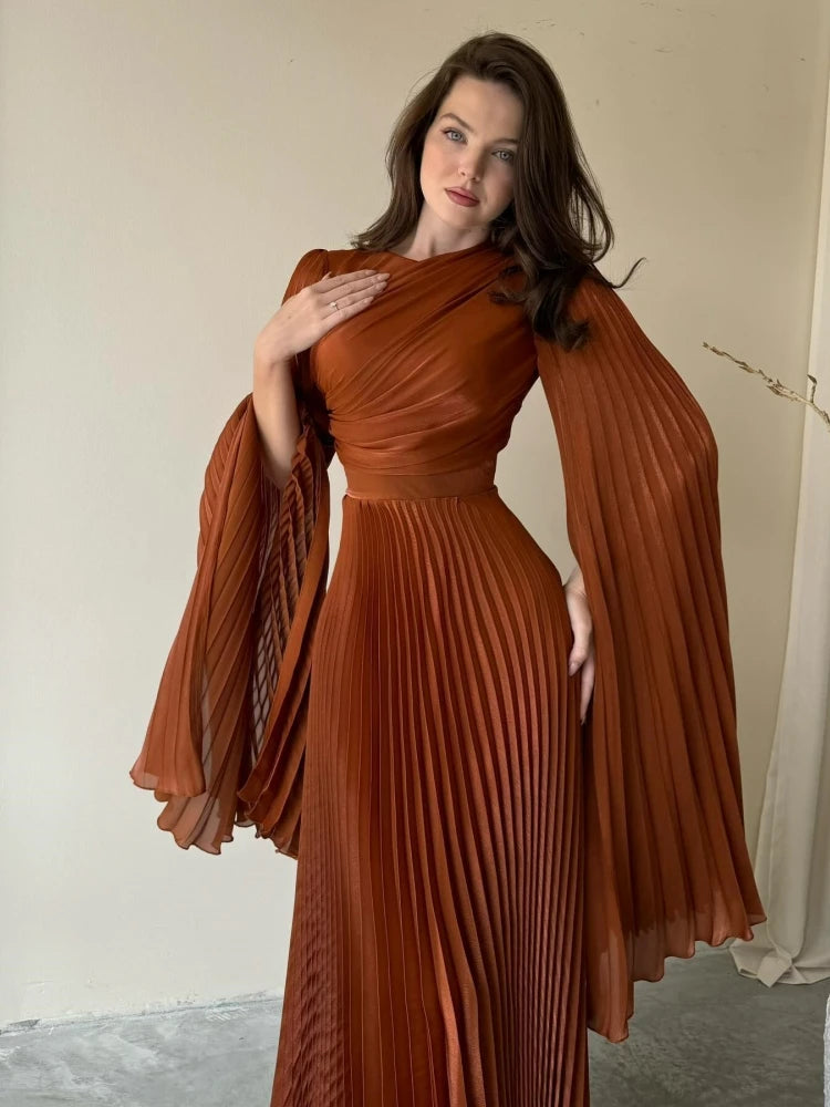 A woman wearing a lace-up batwing maxi dress in a chic, modern style.