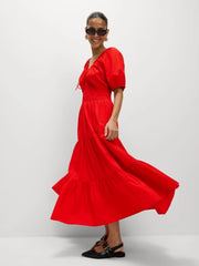 A woman wearing a lace-up puff sleeve maxi dress in a chic, modern style.