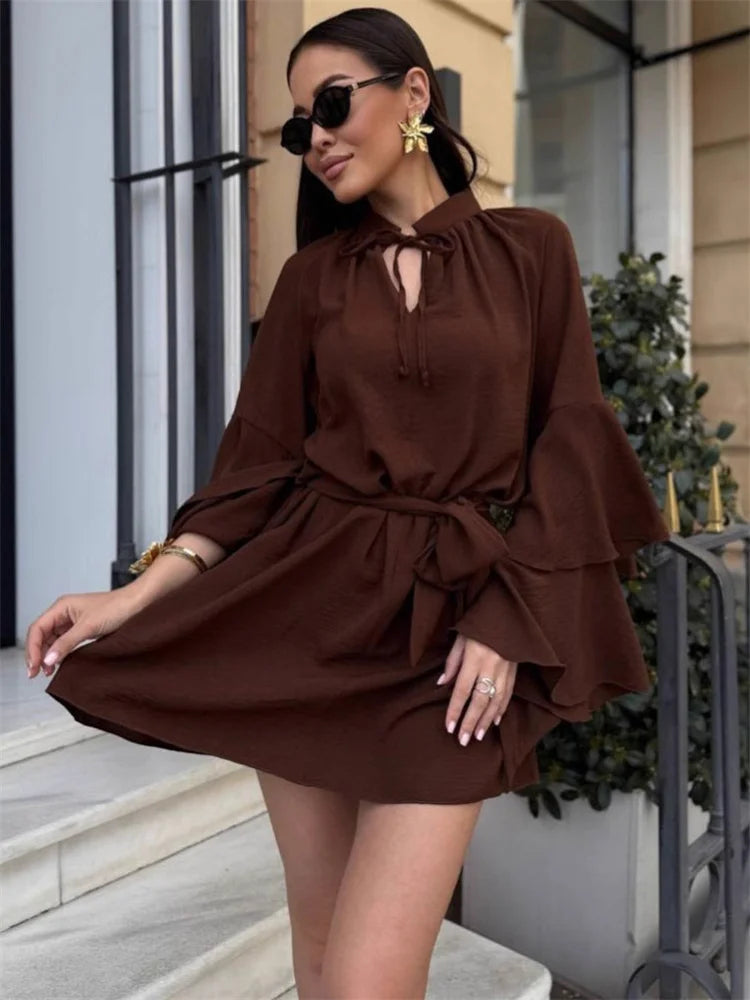 Lace-up V-neck dress styled with sunglasses and earrings on city street