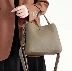 Leather handbag worn crossbody with streamlined design and zip top