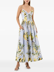 Woman wearing a lemon print maxi dress with a flattering V-neck and empire waist on a white background