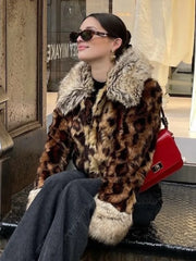 Woman wearing a leopard print coat with fur collar sitting on a bench.