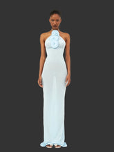 Light blue halter neck 3D flower dress styled for evening wear, Woman wearing a light blue halter neck gown with floral details on a dark background