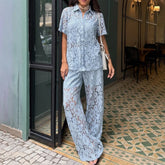 Woman wearing a light blue lace shirt with matching wide-leg trousers outdoors