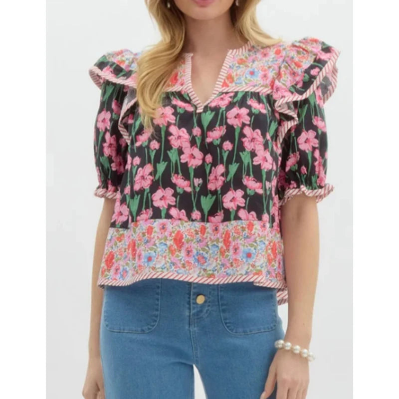 Floral ruffle blouse in a loose silhouette, styled for warm weather with minimal accessories and clean, everyday denim
