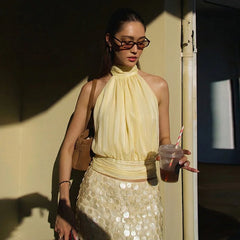 Lightweight halter top in a soft yellow tone with fitted waist
