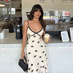 Woman in a playful junior dress in lace patchwork styled for spring and summer
holding a drink in a coffee shop.