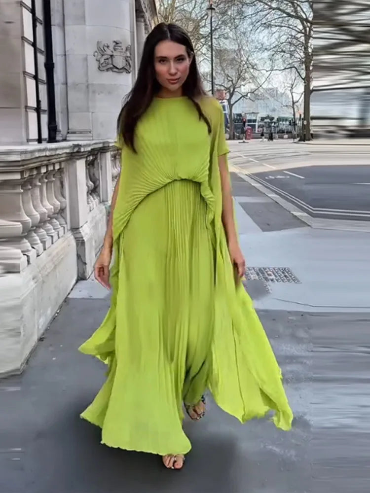 Woman wearing lime green pleated maxi dress on a city street