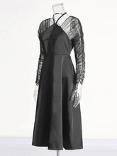 Black dress with sheer sleeves on a mannequin against a white background