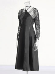 Black dress with sheer sleeves on a mannequin against a white background