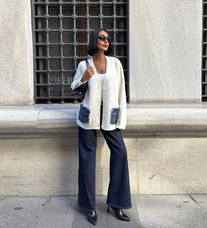 Full outfit shot of a cream button-front cardigan with denim pockets, worn over a light tank with sunglasses and a structured black bag.