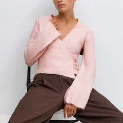 A full-length shot of a long-sleeve loose sweater styled for a night out.