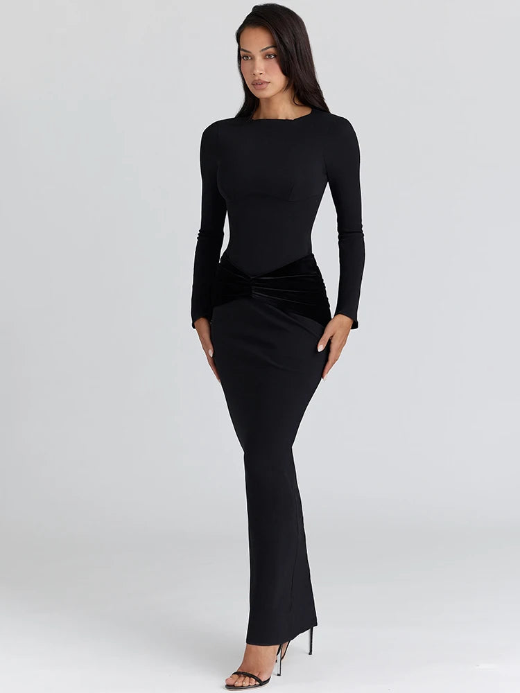 Close-up of waist ruching on a long-sleeve maxi dress showing sculpted contour and smooth floor-length silhouette.
