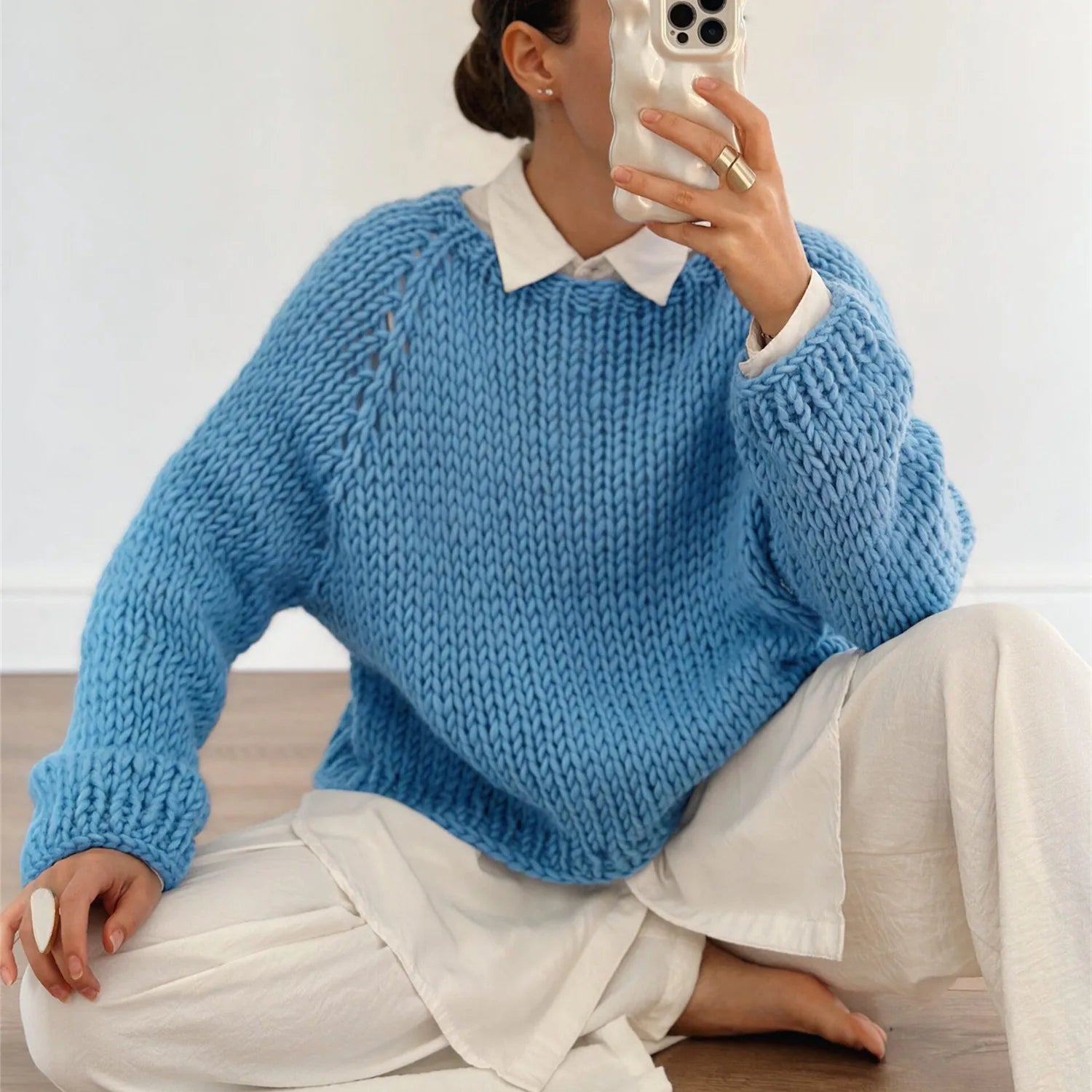 A full-length shot of a long-sleeve round-neck sweater styled for a casual day out.