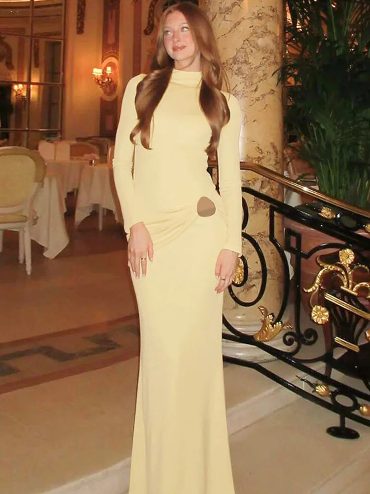 Woman in a yellow dress standing in an elegant interior setting