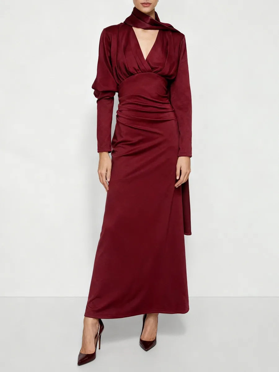 Woman wearing a maroon satin long sleeve maxi dress with a V-neckline.