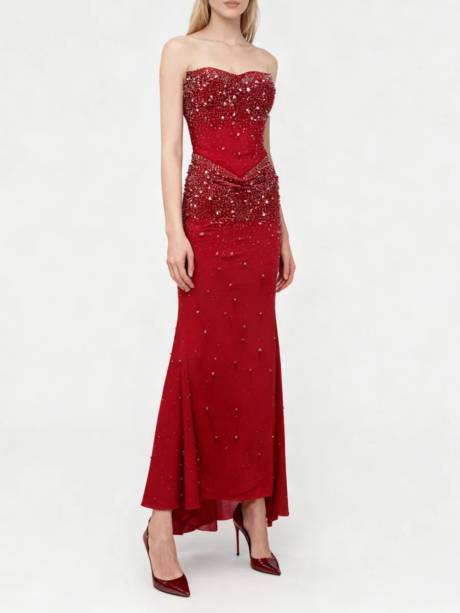A mermaid evening dress with refined sparkle placement and graceful flared hem against a minimalist set.