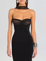 Close-up texture of a sculpted strapless evening dress showing soft mesh bow tie and refined zipper construction.