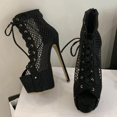 Black high-heeled shoes with mesh design on a white surface