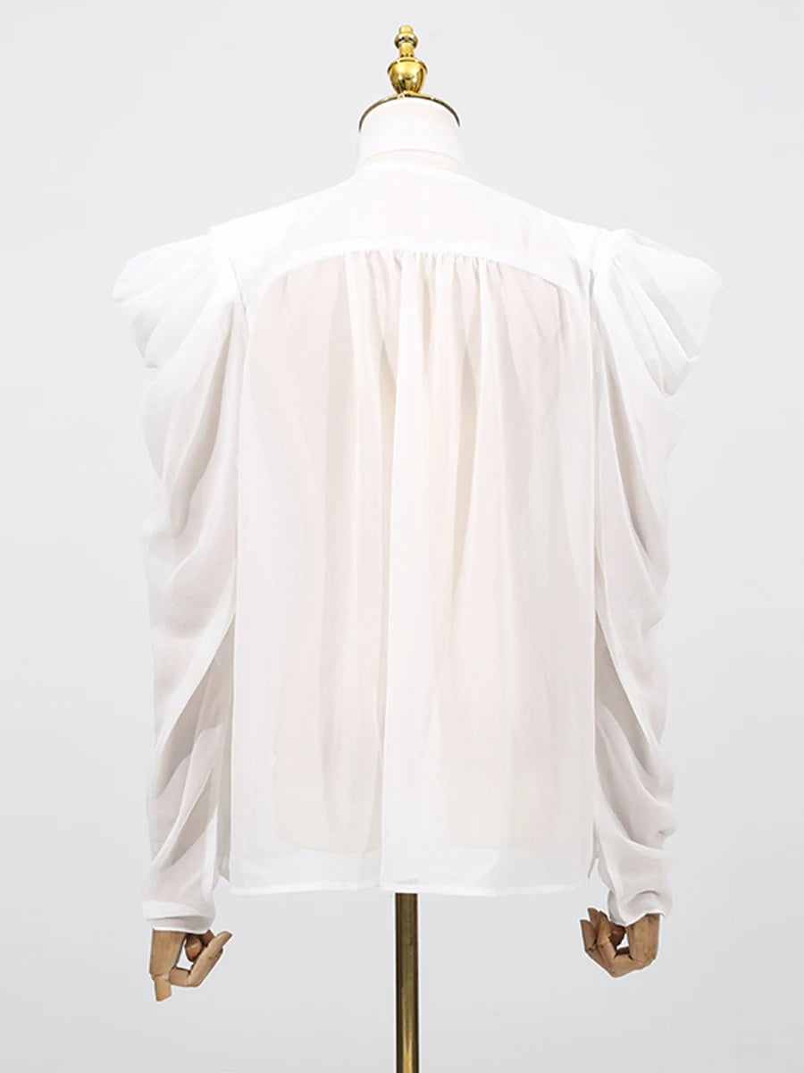 Detail view of the blouse sleeve in motion, showcasing the tie-up design and lightweight fabric flow.