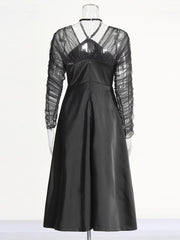 Black dress with sheer sleeves on a mannequin against a white background