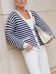Woman wearing navy striped V-neck cardigan with white pants