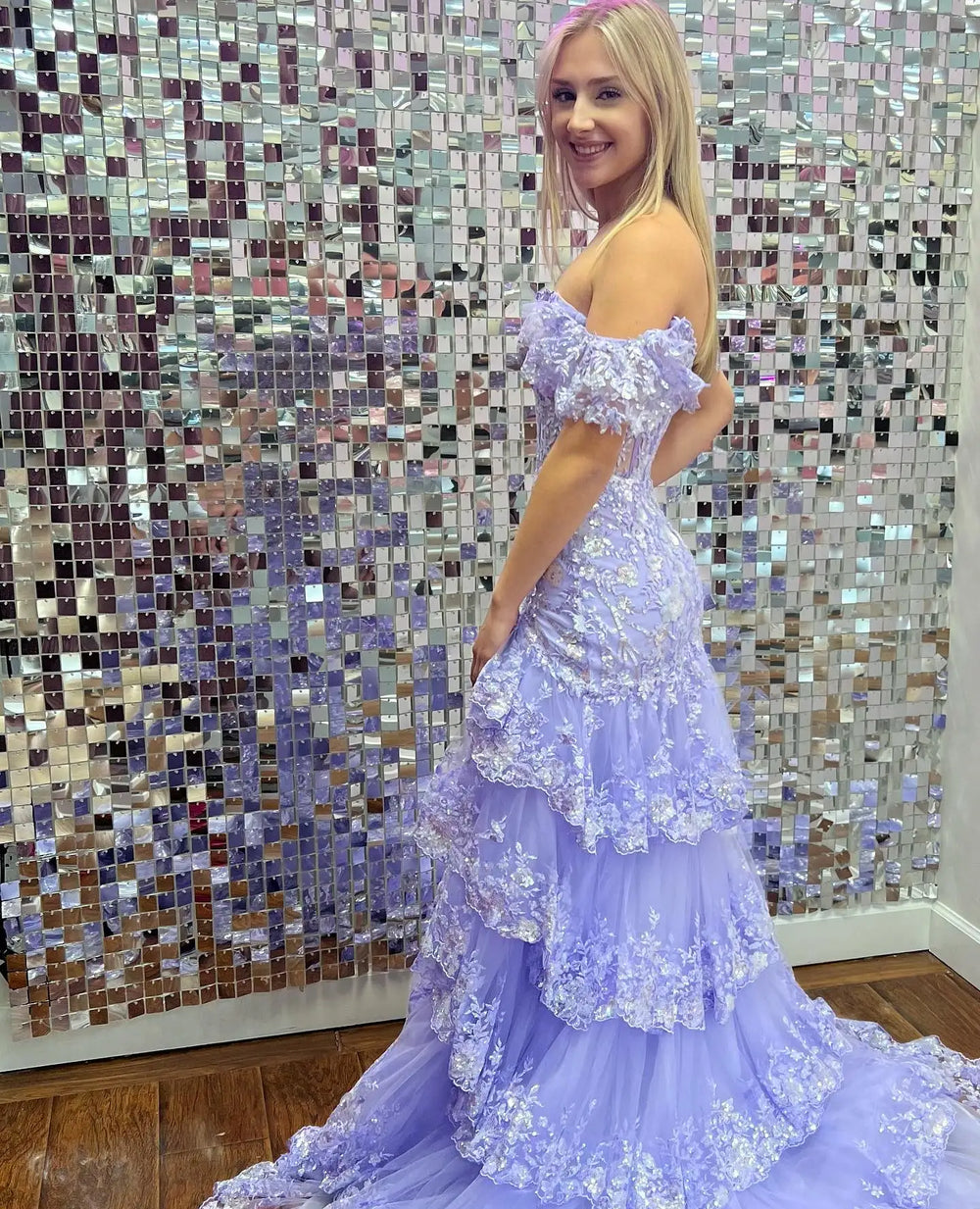 Full-length view of a tiered tulle prom gown with luminous detailing