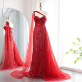 Red one-shoulder mermaid gown with a flowing sheer cape overlay