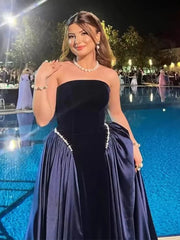 Close-up texture of a strapless velvet gown showing pearl beading and soft sculpted bodice.