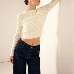 Close-up of pearl button and bow detail on open back knitted sweater