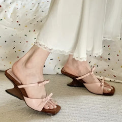 Pink sandals with brown soles worn by a person on a light background