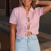 Pink lace-up knit top styled with light-wash jeans for a girly look