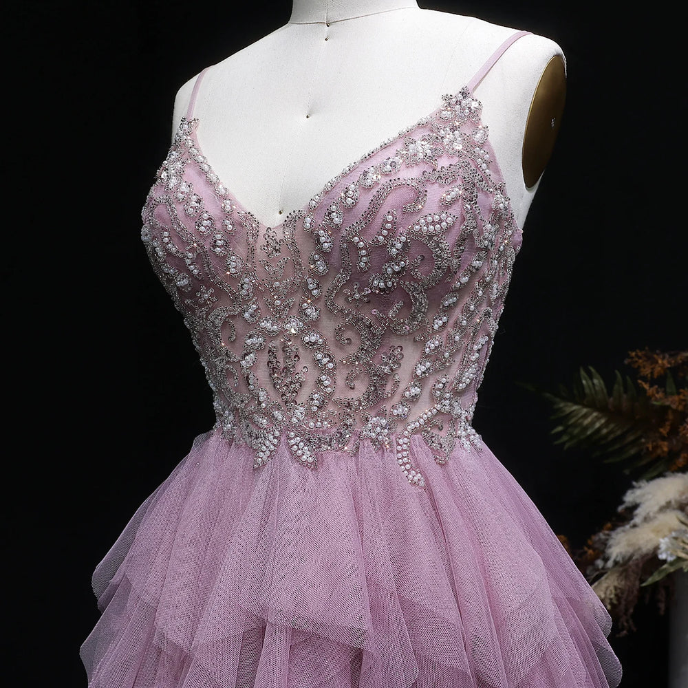 Full-length A-line gown with soft ruffle layers against draped backdrop