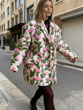 Model walking on a city street in a floral lamb-fleece jacket, showing the relaxed fit and long sleeves in motion.