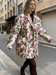 Model walking on a city street in a floral lamb-fleece jacket, showing the relaxed fit and long sleeves in motion.