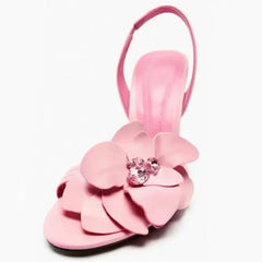 Slip-on pink high heel sandals for women’s luxury evening events. Pink sandal with a flower design on a white background
