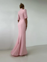 Person wearing a pink evening gown with a plain background