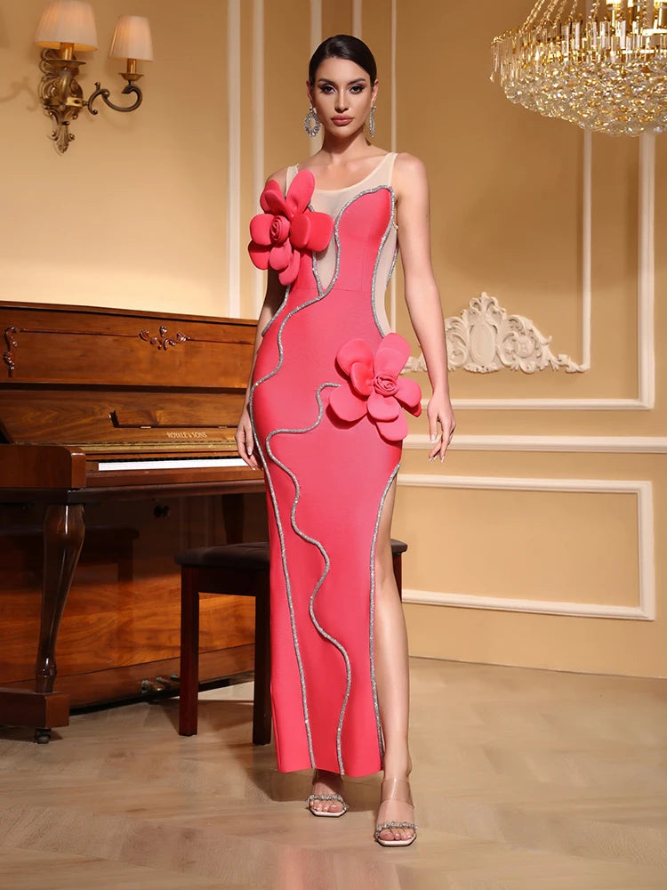 Woman in a pink mesh flower diamond split bandage dress styled for club parties, standing in a room with a piano and chandelier.