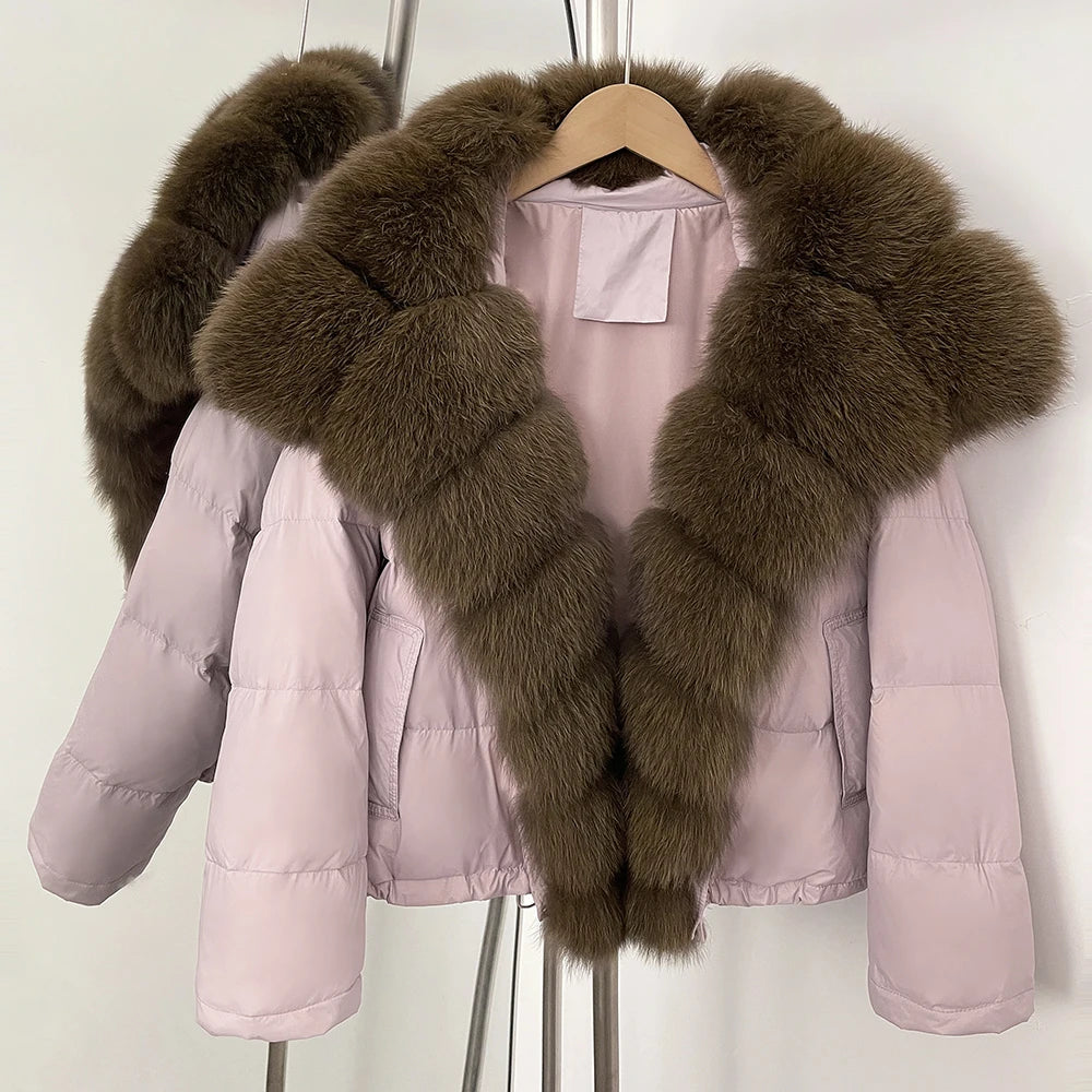 Pink short puffer jacket with a large natural fox fur collar on a hanger.