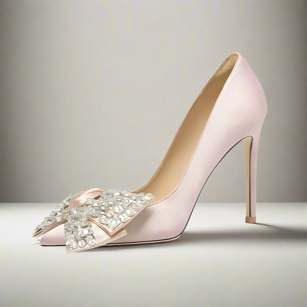 Pink silk pointed stiletto pump with rhinestone butterfly bow for spring banquet on a light gray background