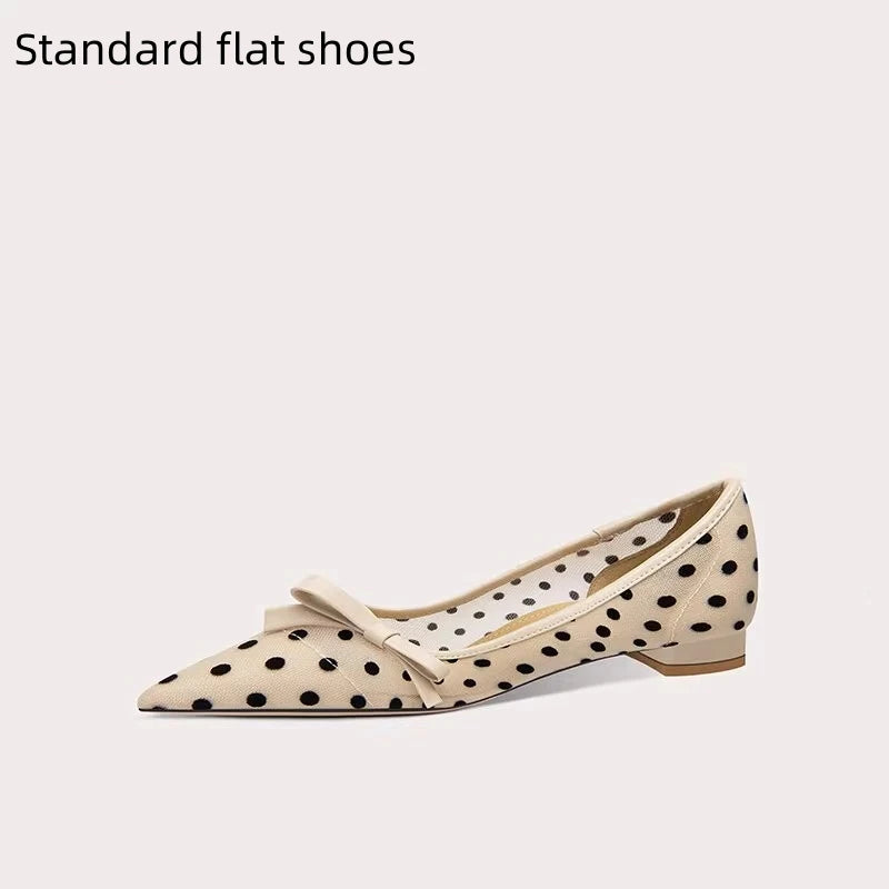 Beige flat shoe with black polka dots and a bow on a white background