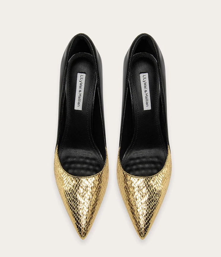 Pair of black and gold pointed-toe shoes on a white background